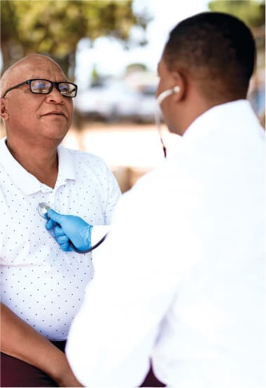 A nurse using a stethoscope on a patient