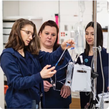 A trio of nurses looking at a tube